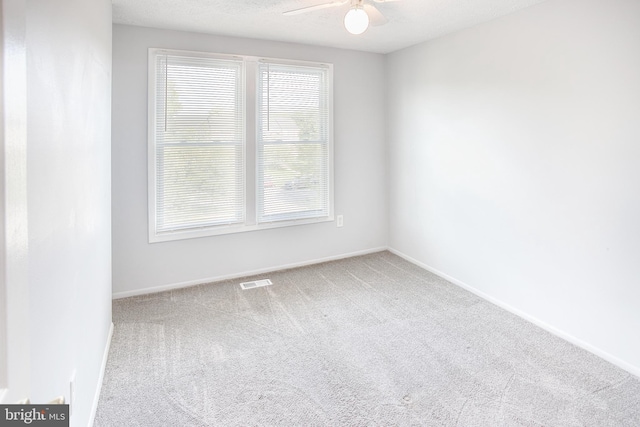 spare room with a ceiling fan, carpet flooring, healthy amount of natural light, and baseboards
