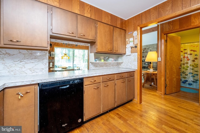 kitchen featuring black dishwasher, light wood finished floors, decorative backsplash, and light countertops