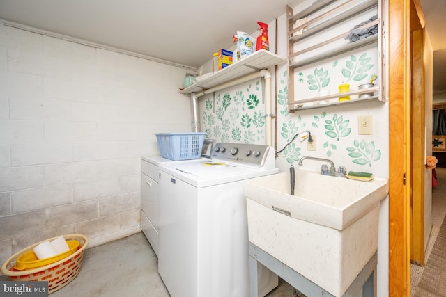 laundry area with washing machine and dryer and concrete block wall
