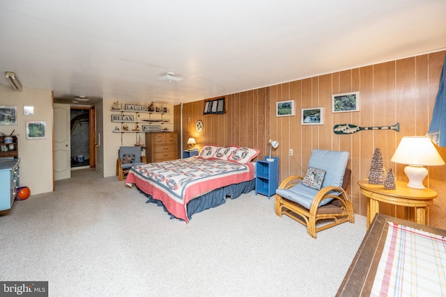 bedroom with carpet flooring and wood walls