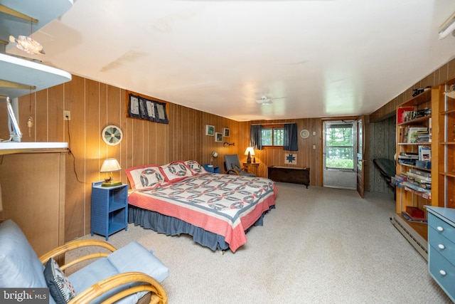carpeted bedroom with a baseboard heating unit and wood walls