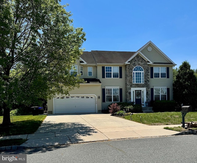 view of front facade with driveway, a front yard, and stone siding