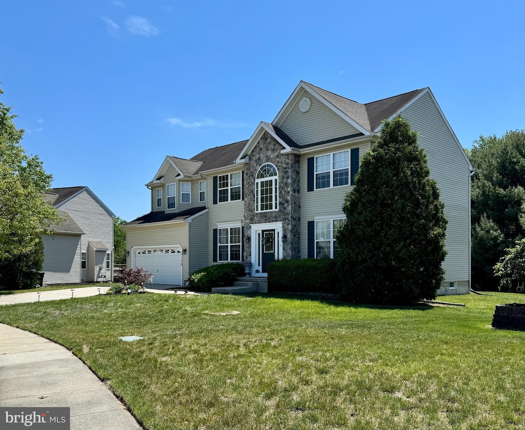 view of front facade featuring a garage, a front lawn, and stone siding