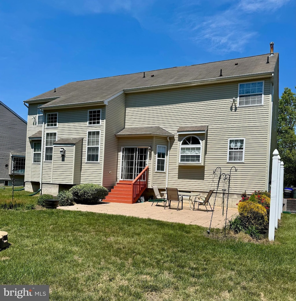 rear view of house featuring a yard and a patio