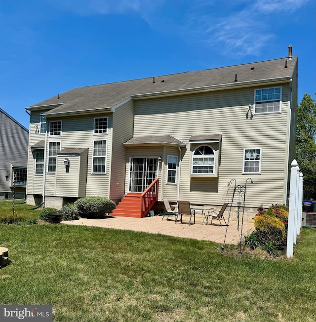 rear view of house featuring a yard and a patio