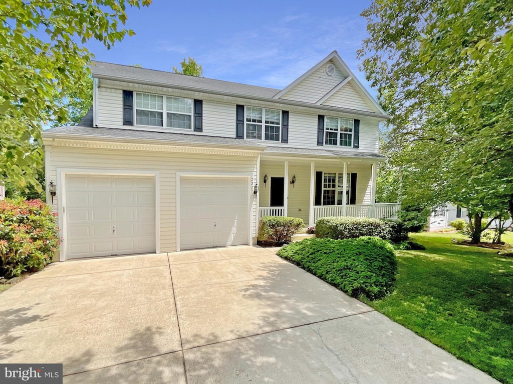 2307 Springdale Ln, Waldorf, MD 20603 - traditional-style home with a porch, concrete driveway, an attached garage, and a front lawn
