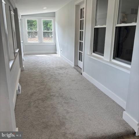 hallway with carpet flooring and baseboards