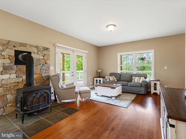 living room with dark wood-style flooring, plenty of natural light, french doors, and a wood stove