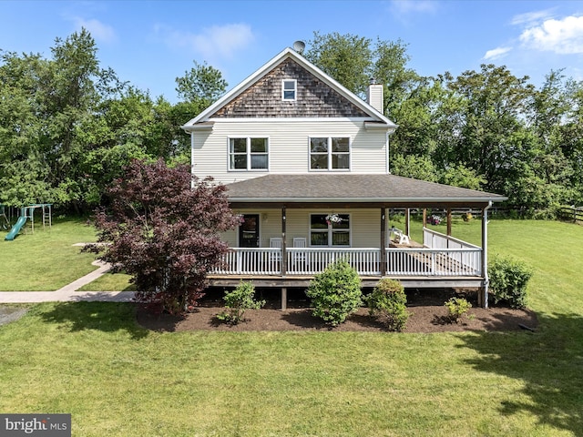 view of front of home featuring a front lawn, a chimney, a shingled roof, and covered porch
