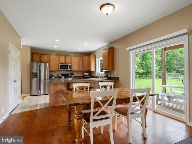 dining room with light wood-style flooring, recessed lighting, and baseboards