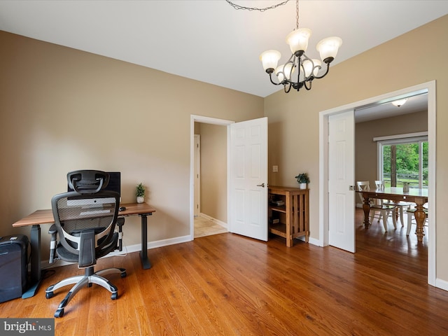 office space with a chandelier, wood finished floors, and baseboards