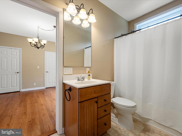 bathroom with a chandelier, vanity, and toilet