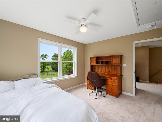bedroom with attic access, light carpet, baseboards, and a ceiling fan
