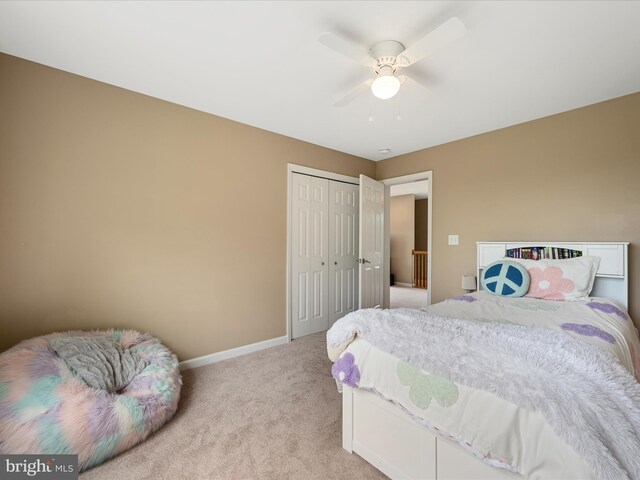 bedroom with light carpet, baseboards, a closet, and ceiling fan