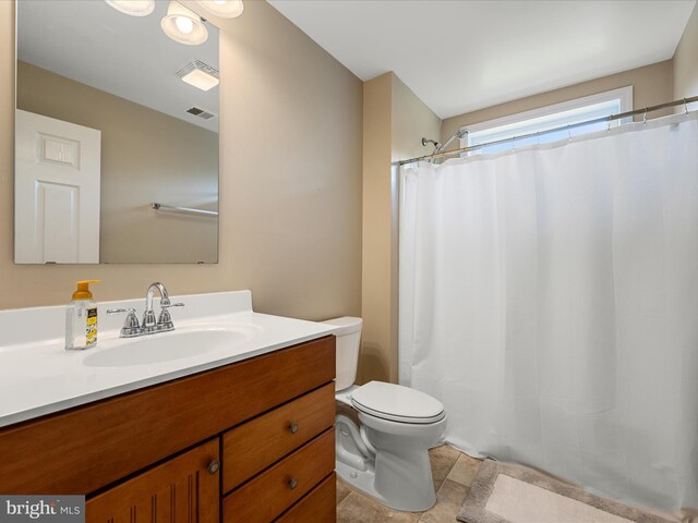 full bath featuring toilet, vanity, tile patterned floors, and curtained shower