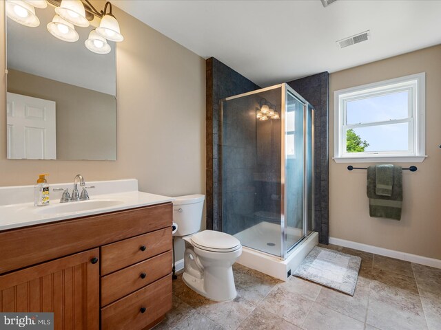 bathroom featuring vanity, a shower stall, toilet, and baseboards