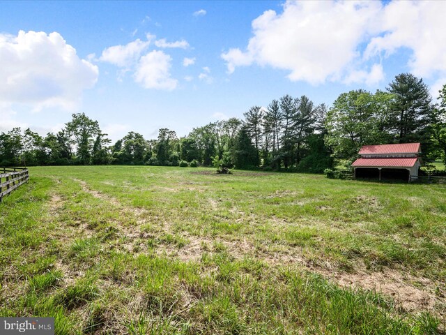 view of yard with a rural view and fence