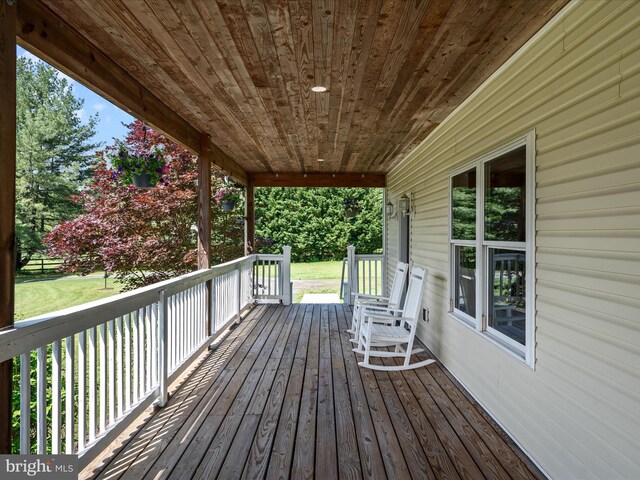 wooden terrace featuring a lawn