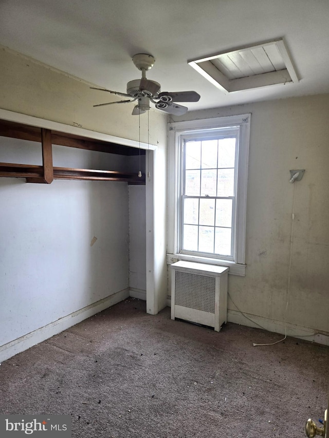 unfurnished bedroom featuring radiator heating unit, carpet, and a ceiling fan