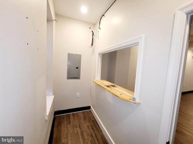detailed view of electric panel, wood finished floors, and baseboards