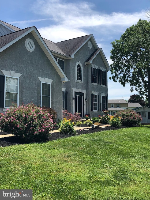 view of front of property featuring stucco siding and a front lawn