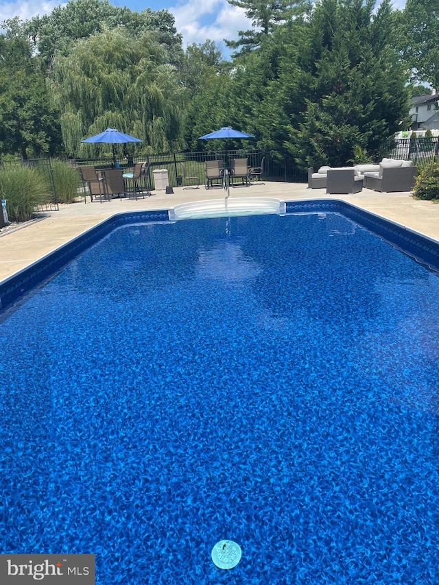 view of swimming pool featuring a patio, outdoor lounge area, fence, and outdoor dining area
