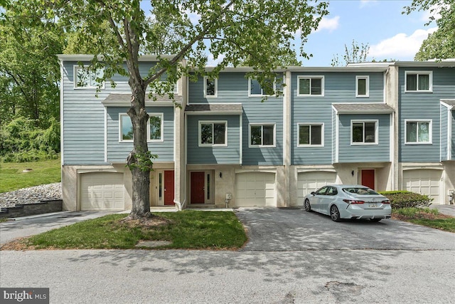 multi unit property featuring driveway, an attached garage, and stucco siding