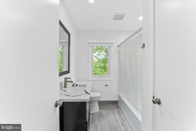 full bathroom featuring wood finished floors, toilet, vanity, baseboards, and shower / bathtub combination with curtain