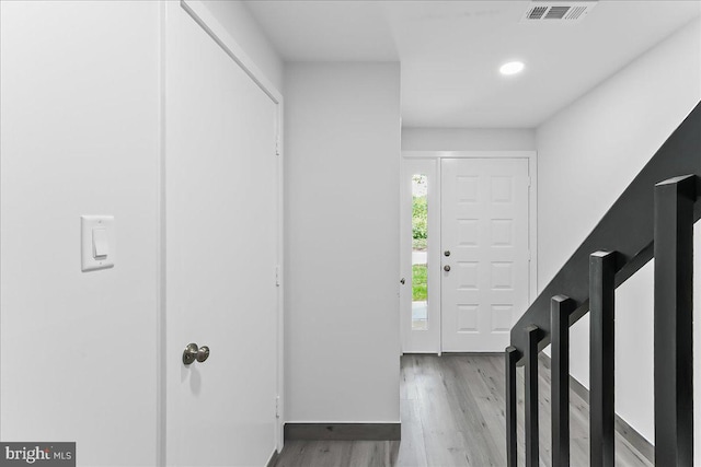 foyer entrance featuring wood finished floors, baseboards, and recessed lighting