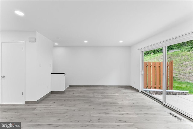 empty room featuring light wood-style floors, recessed lighting, and baseboards