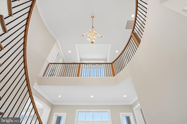 staircase with a towering ceiling, crown molding, a chandelier, and recessed lighting