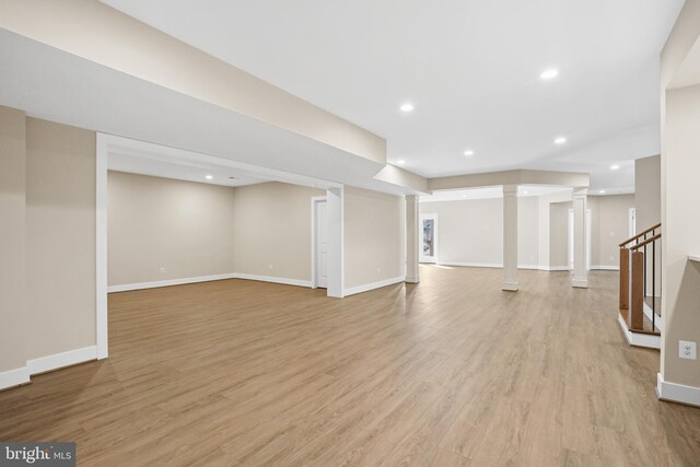 unfurnished living room featuring light wood finished floors, baseboards, stairs, and recessed lighting