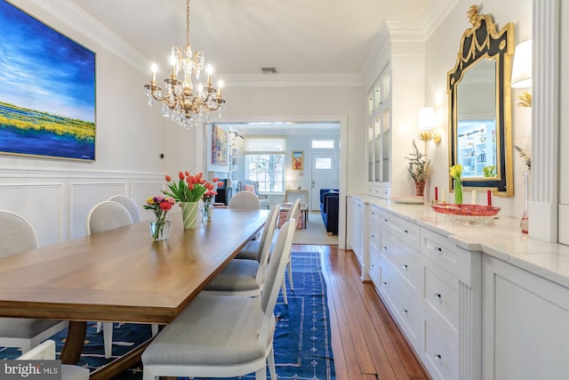 744 7th St SE, Washington, DC 20003 - dining room featuring a chandelier, hardwood / wood-style flooring, crown molding, and wainscoting