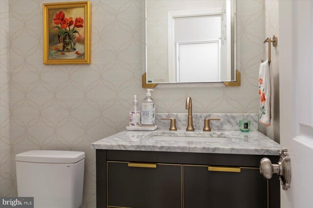 744 7th St SE, Washington, DC 20003 - half bathroom featuring vanity, wallpapered walls, and toilet