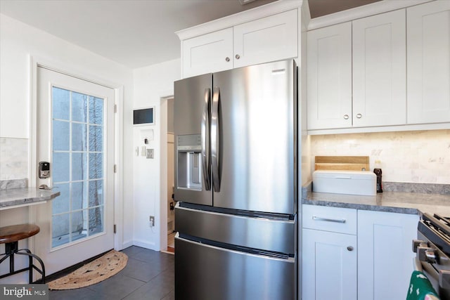 744 7th St SE, Washington, DC 20003 - kitchen featuring stainless steel fridge with ice dispenser, backsplash, white cabinets, and dark tile patterned floors