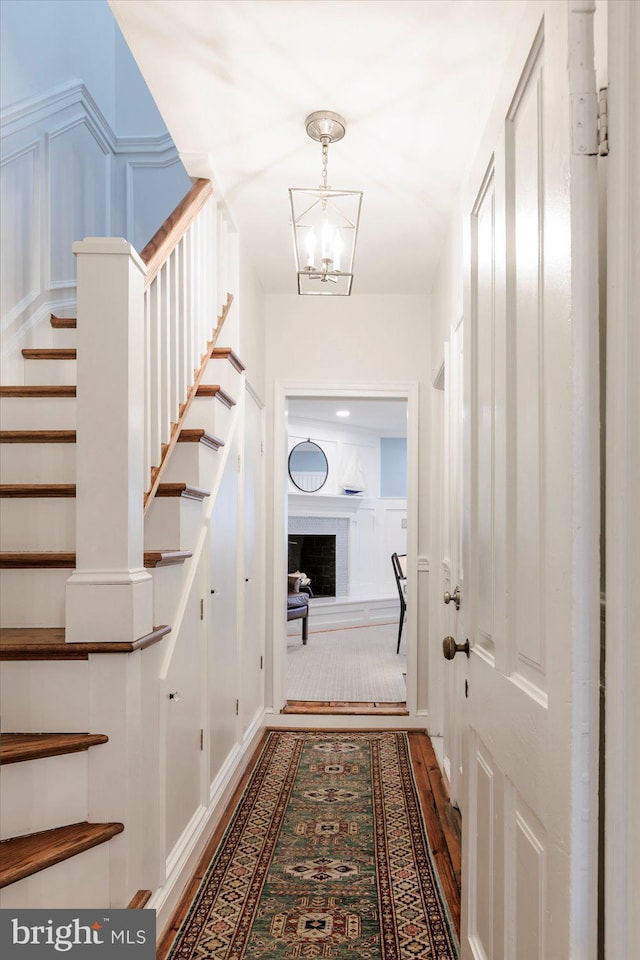 744 7th St SE, Washington, DC 20003 - hall with stairs, wood finished floors, a chandelier, and a decorative wall