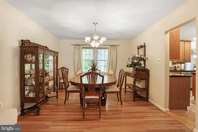 7750 Carrleigh Pkwy, Springfield, VA 22152 - dining area featuring a chandelier, light wood-style floors, and baseboards