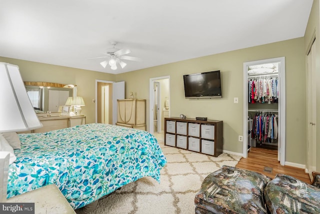 7750 Carrleigh Pkwy, Springfield, VA 22152 - bedroom with a closet, a spacious closet, baseboards, connected bathroom, and wood finished floors