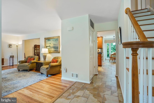 7750 Carrleigh Pkwy, Springfield, VA 22152 - hallway featuring stairway, baseboards, and light stone finish floors