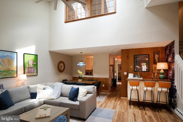 774 W Aaron Dr, State College, PA 16803 - living area featuring a towering ceiling, light wood-type flooring, a baseboard heating unit, and wood walls