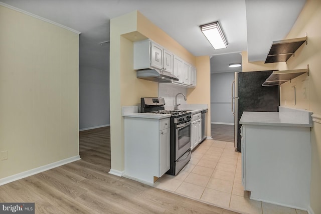 3320 Woodburn Village Dr Unit 32, Annandale, VA 22003 - kitchen featuring appliances with stainless steel finishes, under cabinet range hood, light countertops, light wood finished floors, and baseboards