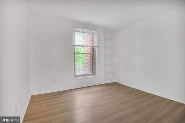3320 Woodburn Village Dr Unit 32, Annandale, VA 22003 - empty room featuring wood finished floors, built in shelves, and baseboards