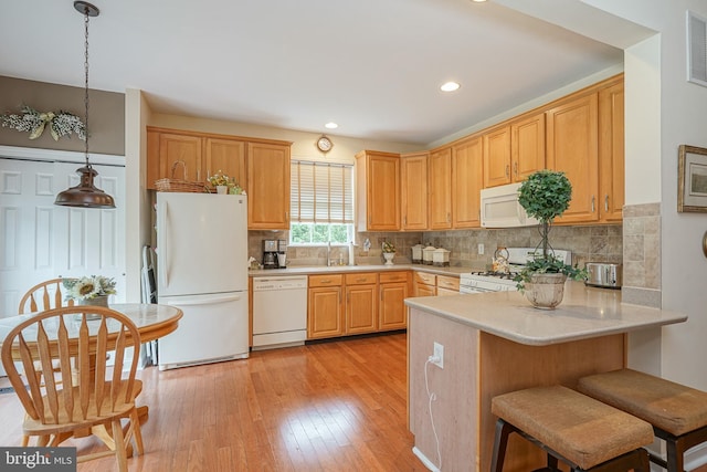 87 Chapel Hill Rd, Mount Laurel, NJ 08054 - kitchen featuring white appliances, light countertops, a peninsula, light wood-type flooring, and decorative backsplash