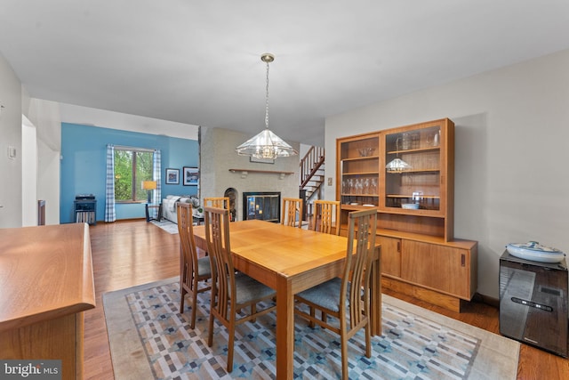 4 Fox Ridge Rd, Glenmoore, PA 19343 - dining space featuring wood finished floors, a brick fireplace, a chandelier, and stairway