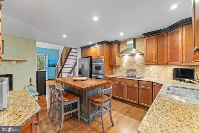 4 Fox Ridge Rd, Glenmoore, PA 19343 - kitchen featuring wall chimney exhaust hood, a sink, stainless steel appliances, light wood-type flooring, and decorative backsplash