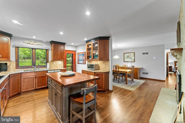 4 Fox Ridge Rd, Glenmoore, PA 19343 - kitchen featuring wooden counters, decorative backsplash, light wood finished floors, glass insert cabinets, and a large fireplace