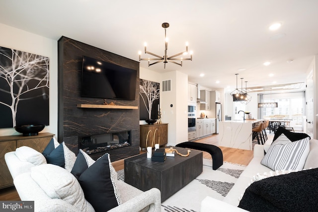 42152 Stone Press Ter, Brambleton, VA 20148 - living room with a chandelier, light wood-type flooring, recessed lighting, and a fireplace