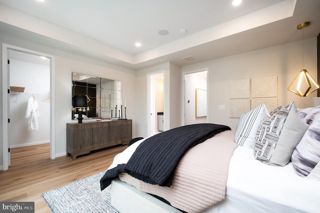 42152 Stone Press Ter, Brambleton, VA 20148 - bedroom with light wood-style floors, recessed lighting, baseboards, and a tray ceiling