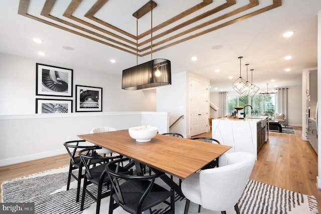 42152 Stone Press Ter, Brambleton, VA 20148 - dining room featuring a raised ceiling, light wood-type flooring, recessed lighting, and baseboards
