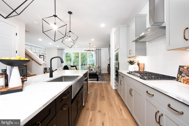 42152 Stone Press Ter, Brambleton, VA 20148 - kitchen with wall chimney exhaust hood, stainless steel appliances, a sink, open floor plan, and backsplash